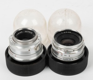 STAEBLE: Two c. 1950s lenses for Braun cameras, with rear caps and clear plastic containers - one Staeble-Lineogon 35mm f3.5 [#739325] and one Staeble-Telexon E 85mm f5.6 [#667636]. (2 items)