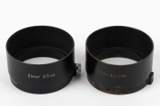 LEITZ: Two black c. 1936 FLQOO lens hoods, one with printed text, the other engraved. (2 items)