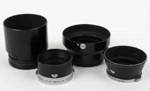 LEITZ: Four Leica lens hoods - one c. 1971 12508 R1.4/50 in black with rear cap, one c. 1956 ITDOO in black and chrome, one c. 1956 ITOOY in black and chrome, and one c. 1951 TNGOO C2219 in black with rear cap. (4 items)