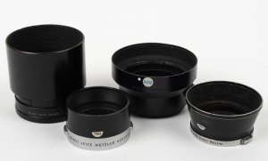 LEITZ: Four Leica lens hoods - one c. 1971 12508 R1.4/50 in black with rear cap, one c. 1956 ITDOO in black and chrome, one c. 1956 ITOOY in black and chrome, and one c. 1951 TNGOO C2219 in black with rear cap. (4 items)