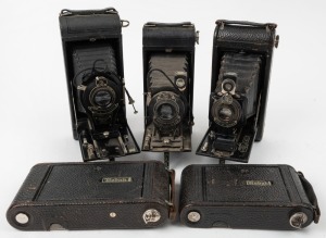 KODAK: Five c. late 1920s vertical-folding cameras - one No. 1A Pocket Kodak with shutter release cable, one No. 1 Kodak Jr., two No. 1-A Kodak Jr. models with varying shutter and lens details, and one No. 2C Pocket Kodak with shutter release cable. (5 cameras)