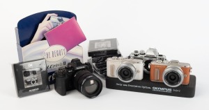OLYMPUS: Twelve promotional items - two Olympus Pen dummy digital cameras, two Olympus OM-D dummy digital cameras, four black and two silver Olympus OM-1 miniatures sealed in retail packaging, one Olympus Mju camera stand, and one Olympus Mju point-of-sale display. (12 items)