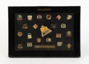 OLYMPUS: Commemorative '10 Million Sold'&nbsp;framed sales retrospective set of twenty-one pins depicting many famous camera models and gold plaque thanking Michaels Camera Video & Digital, together with black protective sleeve.&nbsp;Also one 90th Anniversary Olymp - 2