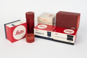 LEITZ: Seven empty Leica lens boxes - one Summicron-M 35mm f2 box with warranty card, one Elmarit-M 21mm f2.8 box with warranty card, one Tele-Elmarit-M 90mm f2.8 box with warranty card, one Summicron-M 50mm f2 box with lens pouch and front and rear lens caps, one E. Leitz Wetzlar red wooden lens box, and one Elmar and one Hektor red cylinder. (7 items)