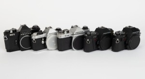 ASAHI KOGAKU: Five SLR camera bodies with metal lugs and plastic body caps - one c. 1973 black Pentax ES II [#6695677], one c. 1977 chrome Pentax K1000 SE [#8355371], one c. 1982 chrome Pentax ME F [#3586640], one c. 1985 black Pentax P30 [#4183660] with 
