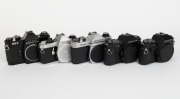 ASAHI KOGAKU: Five SLR camera bodies with metal lugs and plastic body caps - one c. 1973 black Pentax ES II [#6695677], one c. 1977 chrome Pentax K1000 SE [#8355371], one c. 1982 chrome Pentax ME F [#3586640], one c. 1985 black Pentax P30 [#4183660] with