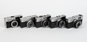 OLYMPUS: Five c. 1967 chrome-body cameras - one Quickmatic 600 [#239381] with E. Zuiko 38mm f2.8 lens, one Quickmatic EES [#125385] with D. Zuiko 36mm f2.8 lens, one Quickmatic EEM [#202513] with D. Zuiko 36mm f2.8 lens, one Trip 35 [#1332885] with D. Zui