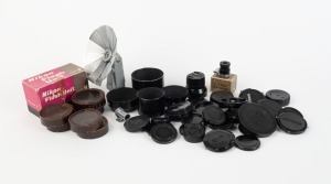 NIPPON KOGAKU: Fifty-two photography accessories - nine black metal lens caps, six lens filters in leather pouches, one chrome 8.5 finder attachment, one Eye Piece Magnifier for Nikon F in maker's box with instruction sheet, four black metal lens caps of varying diameter, one Nikon Flash Unit Model V in maker's box with leather case and instruction booklet, and an assortment of thirty plastic lens and body caps. (52 items)