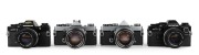 OLYMPUS: Four c. 1970s SLR cameras - one Olympus OM-1 [#527710] with G. Zuiko Auto-S 50mm f1.4 lens [#264437], one Olympus OM-1 MD [#860689] with G. Zuiko Auto-S 50mm f1.4 lens [#350643], one black-body Olympus OM-10 [#1646098] with Zuiko Auto-S 50mm f1.8 - 2