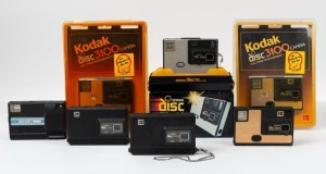 KODAK: Seven c. 1980s disc-film cameras - one Disc 3100, two Disc 3100 models sealed in retail packaging, one Disc 3600, one Disc 4000 in maker's box, and two Disc 6000s. (7 cameras)