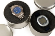 OLYMPUS: Two mint-condition Olympus Mju-branded&nbsp;quartz wristwatches in metal presentation tins, one in stainless steel with analogue face, and one in grey plastic and black rubber with digital face. (2 items)