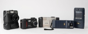 NIPPON KOGAKU: Five c. late 1990s digital cameras showcasing several daring early design choices - one Coolpix 100, one Coolpix 300 with unusual coupled touchscreen PDA and voice memo feature, one Coolpix 900, one Coolpix 5000 with coupled MB-E5000 batter