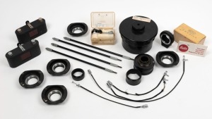 LEITZ: Eighteen accessories - one APDOO self-timer, two ELDIA film copiers, one Correx developing tank, two MBOOC booster cells, one OUBIO adapter, one Chico flash unit, four shutter release cables, one VXZOO adapter, one Repro N extension tube element, one Telyt extension tube element, one set of test slides, one Leitz box of 100 Cover Glass Plates, and one BOOWU stand with DIN A4/A5/A6 elements. (18 items)