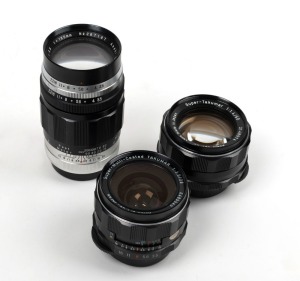 ASAHI KOGAKU: Three screw-mount lenses all with rear lens caps - one SMC Takumar 28mm f3.5 [#6485545], one Takumar 135mm f3.5 [#287167], and one Super-Takumar 50mm f4 [#2148974] with front lens cap. (3 items)