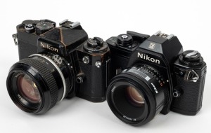 NIPPON KOGAKU: Two c. 1978 black-body SLR cameras - one Nikon FE [#3502232] with Nikkor 50mm f1.4 lens [#2904261], and one Nikon EM [#6711920] with AF Nikkor 50mm f1.8 lens [#2018681]. (2 cameras)