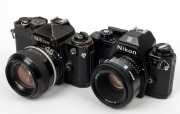 NIPPON KOGAKU: Two c. 1978 black-body SLR cameras - one Nikon FE [#3502232] with Nikkor 50mm f1.4 lens [#2904261], and one Nikon EM [#6711920] with AF Nikkor 50mm f1.8 lens [#2018681]. (2 cameras)