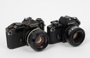 NIPPON KOGAKU: Two c. 1978 black-body SLR cameras - one Nikon FE [#3502232] with Nikkor 50mm f1.4 lens [#2904261], and one Nikon EM [#6711920] with AF Nikkor 50mm f1.8 lens [#2018681]. (2 cameras) - 2