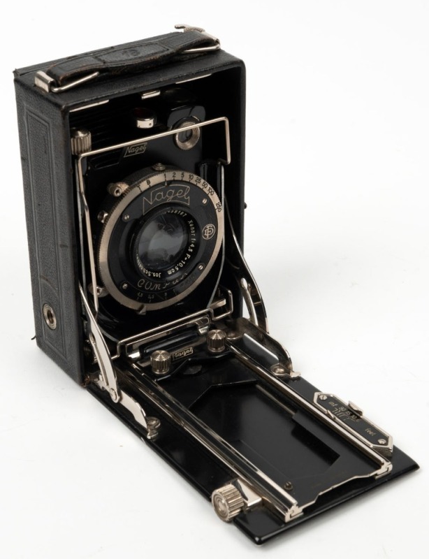 NAGEL: Recomar 18 folding plate camera, c. 1928, with Xenar 105mm f4.5 lens [#438187] and Compur shutter, together with leather case containing black hood cloth, wrist strap, camera back, and six metal film holders.