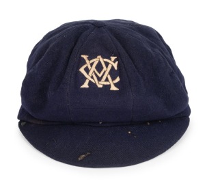 CLARRIE GRIMMETT'S VICTORIAN CRICKET ASSOCIATION Team Cap, dark blue wool, embroidered with the monogrammed initials of the V.C.A. in cream silk thread; label of Buckley & Nunn. Grimmett appeared in five matches as part of the V.C.A. team between 1918 and