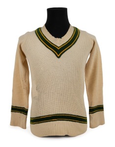 CLARRIE GRIMMETT'S 1935-36 AUSTRALIAN TEAM woollen jumper, with yellow and green trim and embroidered label by the maker "Roslyn". Accompanied by an original photograph og Grimmett wearing this jumper and his 1935-36 Baggy Green cap. (2 items). Provenance: The Clarrie Grimmett Collection; his family, by descent.