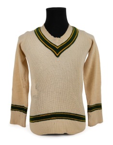 CLARRIE GRIMMETT'S 1935-36 AUSTRALIAN TEAM woollen jumper, with yellow and green trim and embroidered label by the maker "Roslyn". Accompanied by an original photograph og Grimmett wearing this jumper and his 1935-36 Baggy Green cap. (2 items). Provenance