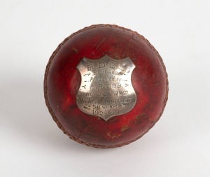 A trophy cricket ball with silver plaque affixed, engraved dedication "B. D. C. L., B-Grade - Presented by A. ROSS to L. Brown. Highest Aggregate. 50 wickets - 1928-29".