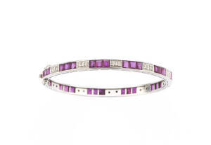 BANGLE: Ruby and diamond channel set bangle. 14ct white gold. 14.6 grams.
