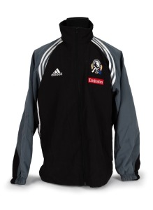 Nathan Buckley’s Collingwood players’ jacket circa 2001-02. Black adidas jacket with full zip, adidas logo on right breast, Collingwood logo on left breast, above small red Emirates patch. Black front with grey sleeves and white striping/highlights. Large