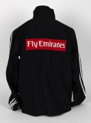 Nathan Buckley&rsquo;s Collingwood players&rsquo; jacket, circa 2006. Black adidas full-zip jacket with adidas logo top right, Emirates top left and Collingwood logo beneath that. Fly Emirates single line logo on reverse. - 4