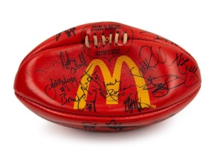 100th GAME FOOTBALL: A red Sherrin football with yellow McDonald’s logo, signed by Nathan Buckley and other players including Josh Mahoney, Brad Cassidy, Andrew Schauble, Jason Wild, Scott Russell, Simon Prestigiacomo, Paul Williams and others. Note: the signatures date the ball to 1997; believed to be souvenired from Buckley’s 100th game v Fremantle at Victoria Park.
