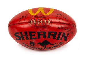 100th GAME FOOTBALL: A red Sherrin football with yellow McDonald’s logo that has been signed by umpires Bryan Sheehan (#9), Jamie Love (#28, '96-99) and Keith Callaghan #33 who were in charge for Buckley's 100th career game, Collingwood v Fremantle in 1997.