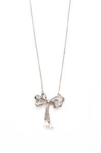 PENDANT: Pearl and diamond ribbon pendant on chain. Yellow gold and silver.