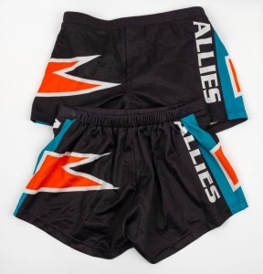 Nathan Buckley’s Allies playing shorts from 1996-97. Black with blue piping and orange ‘lightning’ flashes. 2 pairs, one size 16 and the other size 18.