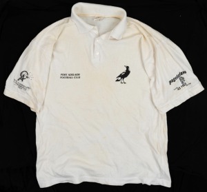 Nathan Buckley’s Port Adelaide Football Club white team polo. With magpie logo on left breast, and ‘Port Adelaide Football Club’ on right breast. Sponsors names (‘Pagel Glass’ and ‘Class A Jewellers’) on sleeves. Dirty