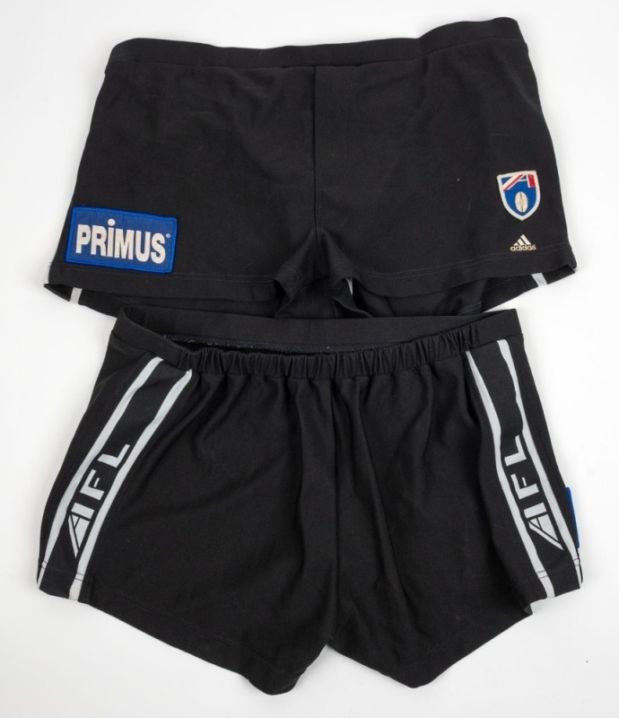 Nathan Buckley’s Collingwood playing shorts, circa 1999. Black shorts with blue Primus patch on one side, AFL logo and adidas logo on the other. White stripes and AFL branding along sides. (2 pairs).