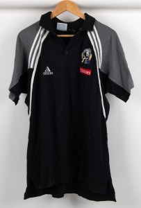 Nathan Buckley’s Collingwood polo circa 2001-03. A black shirt with grey panelling on shoulders and white trim/striping.