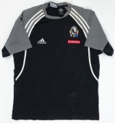 Collingwood T-shirt/training top, early 2000s. Black shirt with adidas logo on right breast and Collingwood logo on left breast, above small red Emirates patch. White stripes and grey sections on sleeves/shoulders. First issued 2001. (2 examples; one worn - 3