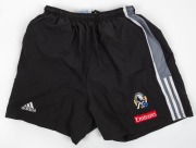 Nathan Buckley’s Collingwood training shorts, early 2000s. Adidas logo on right, Collingwood logo on left with Emirates patch below. Black shorts with grey panel with white stripes along edge. (2 pairs, different sizes). - 3