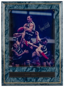 Gary Ablett Sr. taking a spectacular mark over the heads of  his teammates and Melbourne players, signed, framed, and attractively presented. Overall 38 x 28cm