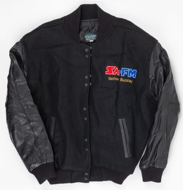 SA FM Bomber jacket. Bomber jacket with SA-FM badging on left breast, with ‘Nathan Buckley’ in yellow beneath it. SA-FM in large lettering on rear. Given to Buckley during a promotion by the station.