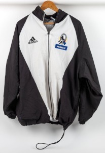 Collingwood players' jacket 1998. Adidas full-zip jacket with Collingwood logo on left breast above blue Primus patch. Mainly white front with black sleeves/sides and white stripes. Large white adidas logo on rear, above large white ‘Primus Telecommunications’ patch. "NB - 5" to label.