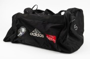 Nathan Buckley&rsquo;s Collingwood kitbag circa 2000. Large adidas black kitbag with the number &lsquo;5&rsquo; written on both ends. Collingwood logo, adidas and Fly Emirates badging along one side.