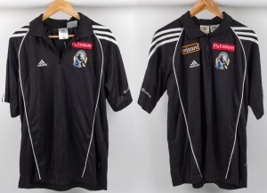 Collingwood players’ collared T-shirts with zips, circa 2006. Black adidas logo with Wizard logo top right, Fly Emirates top left and Collingwood logo beneath that. White stripes and Lexus branding on sleeves. Also, a players’ shirt circa 2005-06, black a