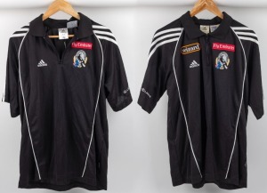 Collingwood players’ collared T-shirts with zips, circa 2006. Black adidas logo with Wizard logo top right, Fly Emirates top left and Collingwood logo beneath that. White stripes and Lexus branding on sleeves. Also, a players’ shirt circa 2005-06, black adidas half-zip top with adidas logo top right, Fly Emirates top left and Collingwood logo beneath that; blank on reverse. White stripes and Lexus branding on sleeves. Same design as above but without Wizard patch. (2).