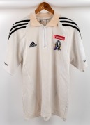 Collingwood players’ polo/top, circa 2006. White shirt with collar and half-zip, adidas logo on right breast, red Emirates on left above Collingwood logo. All white with black adidas stripes.