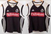 Nathan Buckley Collingwood training tops, circa 2006; black fronts with red Fly Emirates patch, adidas and Collingwood logos above, cut away shoulders with white highlights, V-neck. Stripes along sides and Wizard logo on the backs. Two examples, one in qu