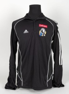 Nathan Buckley’s Collingwood players’ jacket/track top, circa 2006. Black adidas short-zip jacket with adidas logo top right, Fly Emirates top left and Collingwood logo beneath that. Fly Emirates logo is the single line version. Rear is blank.