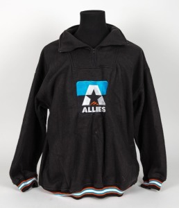 Nathan Buckley’s Allies team jacket from 1996-97. Thick, short-zipped, collared jacket with Allies logo in middle (teal/black with black star and orange flash), with orange, teal and white trim.