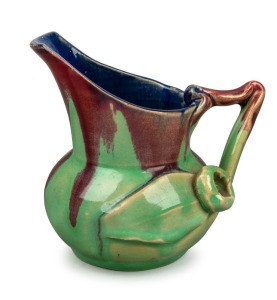 REMUED pottery jug with applied gumnut, leaf and branch handle, beautifully glazed in early lime green, pink and blue colourway, incised "Remued, 119/M", 11cm high