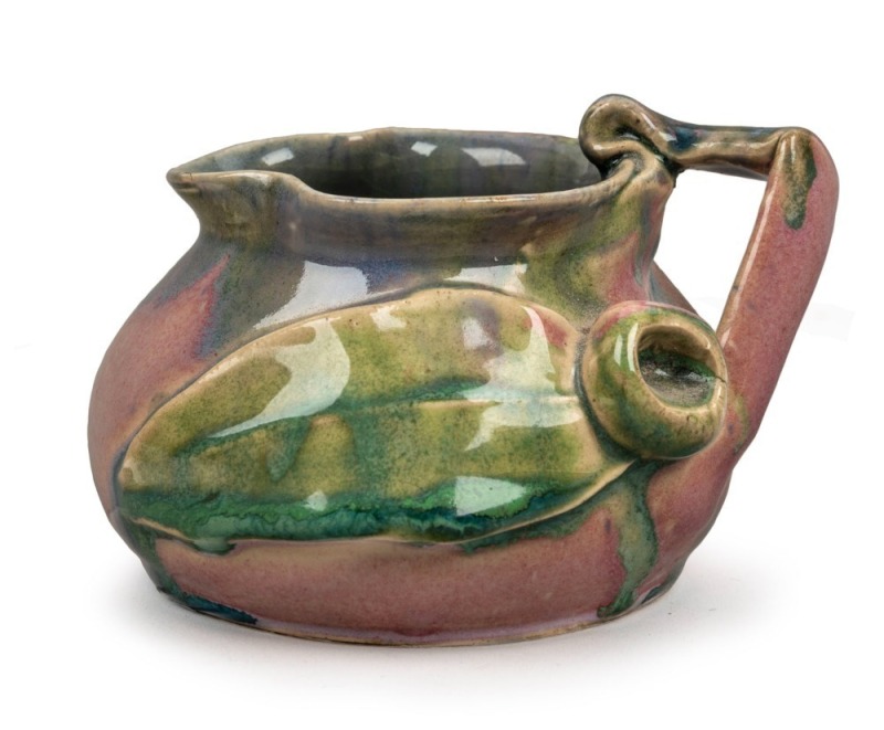 REMUED pottery jug with applied gumnut, leaf and branch handle, glazed in pink, mauve and green, incised "Remued 173/SM, Hand Made", 8cm high, 11cm wide